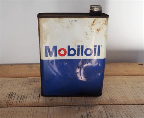 An Old Mobil Oil Can Sitting On Top Of A Wooden Table