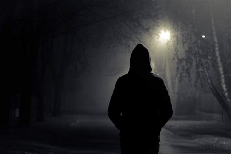 Silhouette Of Hooded Person With Spooky Dark Background