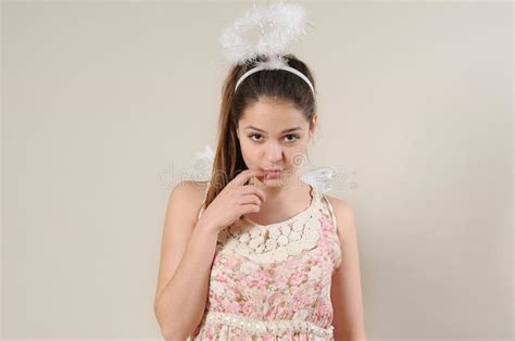 Portrait Of Cute Very Shy Angel Girl With Finger Near Her Mouth Stock