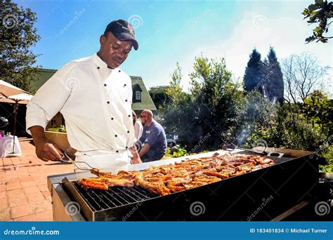 African Man Working A Bbq Grill At Outdoor Event Editorial Stock Image