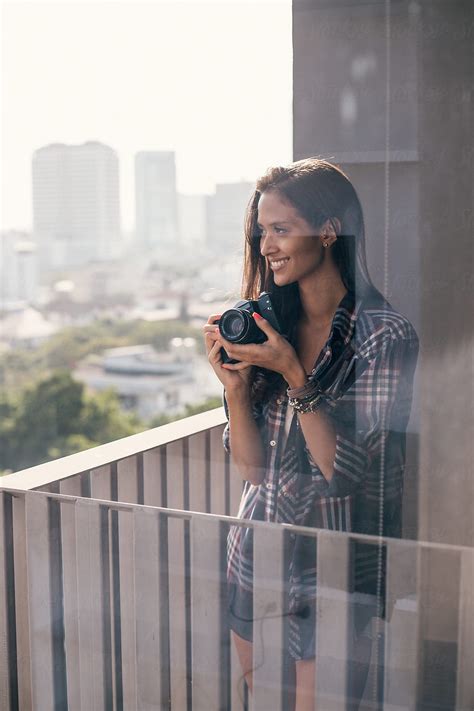 Beautiful Girl Looking At The City And Holding Her Retro Camera By Stocksy Contributor Jovo