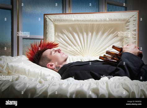 A Deceased Young Man In A Coffin Holding Beer Bottles Stock Photo
