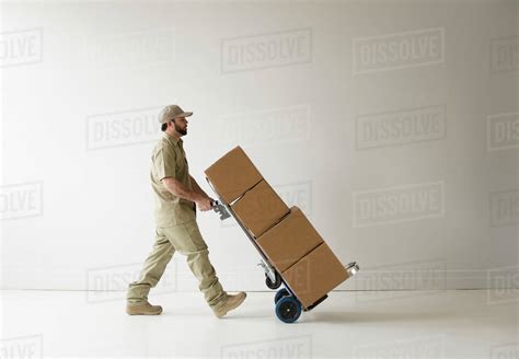 Delivery Man Walking With Push Cart Stock Photo Dissolve