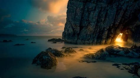 Light From Sunrise Through A Sea Cave On The Isle Of Skye Scotland