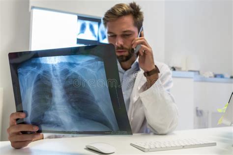 Serious Attractive Doctor Examining An X Ray Stock Photo Image Of