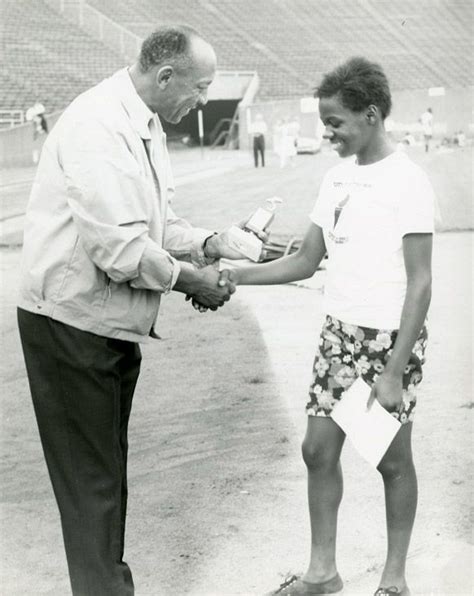 Jesse Owens Shakes Hands With A Young Runner At A Track Meet 1970s