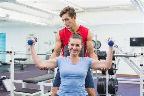personal trainer helping client lift dumbbells stock image image of recreation camera 45092775