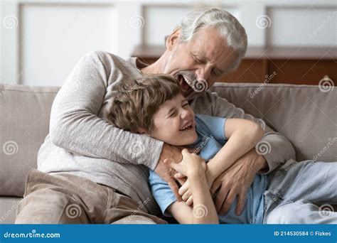 Overjoyed Senior Grandfather Play With Small Grandson Stock Photo