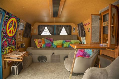 The Inside Of A Camper With Couches Tables And Pictures On The Walls