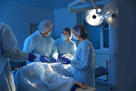 Team Of Doctors Performing Operation In Surgery Room Stock Image