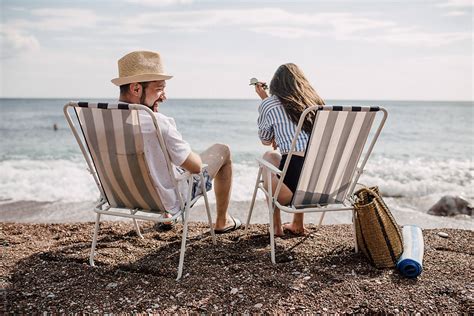 couple sitting on beach chairs and having a conversation by boris jovanovic beach couple