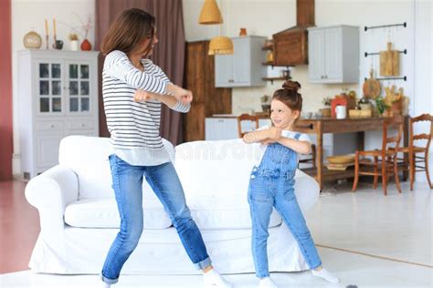 Cheerful Mother With Little Daughter Dancing At Favourite Song In