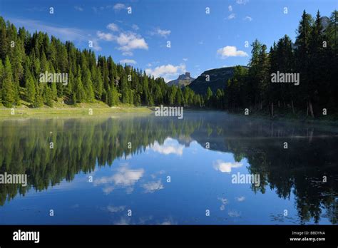 Mountain Range And Forest Reflected In Lake Antorno Italy Stock Photo