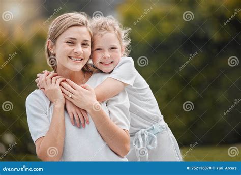 Portrait Of An Adorable Little Girl Hugging Her Mother From Behind