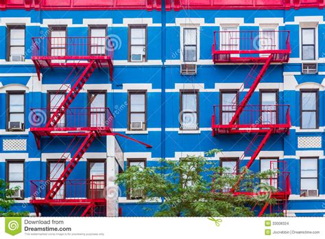 Colorful Apartment Building In Ny With Red Fire Escapes