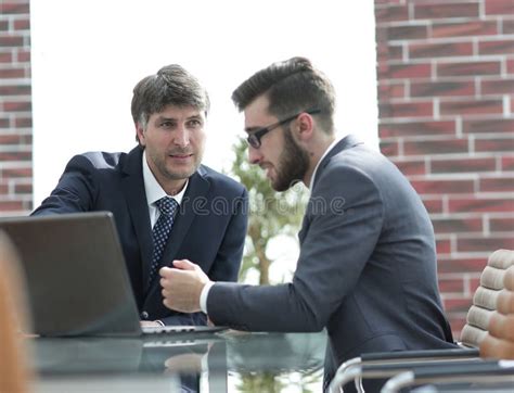Two Businessmen Working Together Using Laptop On Business Meeting In
