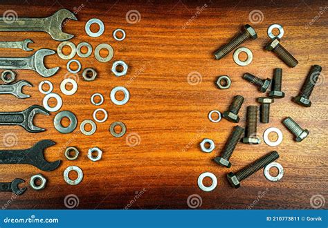 Different Wrenches Bolts Nuts And Washers On A Brown Wood Texture