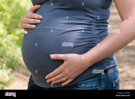 Cropped Side View Of A Pregnant Woman With Her Hands Around Her Unborn