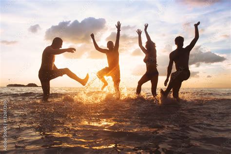 Group Of Happy Friends Having Fun Together On The Beach At Sunset