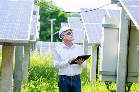 Engineer Holding Digital Tablet Working In Solar Panels Power Farm