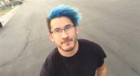A Man With Blue Hair And Glasses Is Standing In The Street