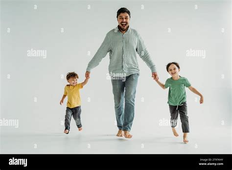 Padre Feliz Que Se Toma De La Mano Con Los Niños Y Corre Contra El