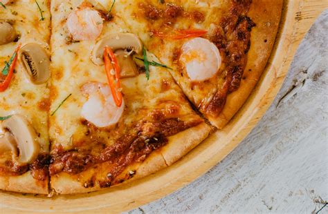 Appetizing baked sliced seafood pizza with mushrooms · Free Stock Photo