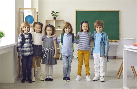 Group Portrait Of Happy Elementary School Children Standing In A Modern