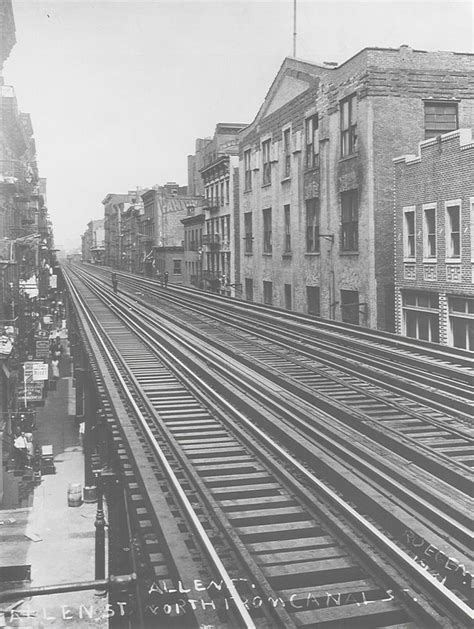 An Old Black And White Photo Of Train Tracks In The Middle Of A City Street