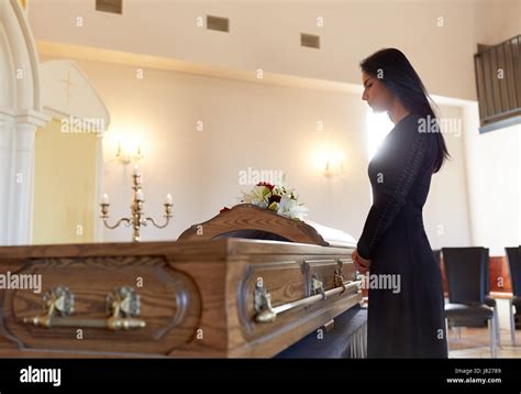 Sad Woman With Coffin At Funeral In Church Stock Photo Alamy