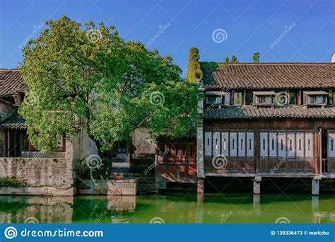 Traditional Chinese Houses And Trees By Water In The Old Town Of