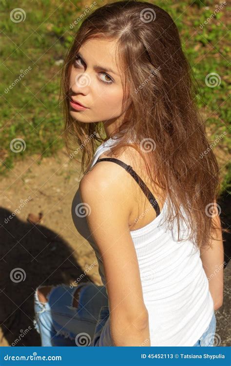 Schönes Sexy Mädchen Mit Dem Langen Haar In Einem Weißen T Shirt Und In Jeans Die Im Wald An