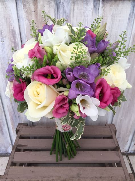 wedding bridal bouquet made up of white pink and purple freesia white rose and lisianthus