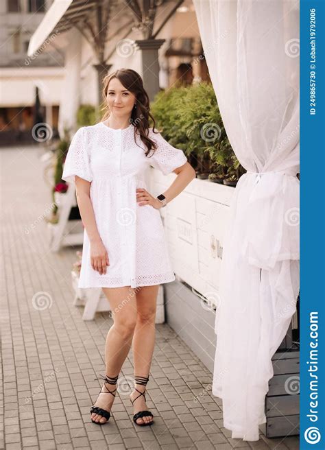 A Beautiful Woman In A White Dress At Sunset In The City Evening