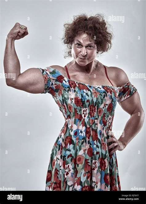 Girls Power Metaphor With Muscular Mature Woman Flexing Biceps Stock