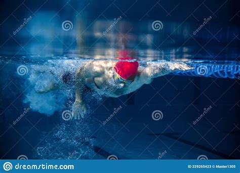 Underwater View Of Professional Male Swimmer In Red Cap And Goggles In