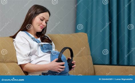 Pregnant Woman Puts Headphones To Bump And Shakes Head Stock Image