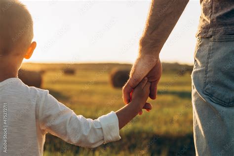 Foto Stock Fathers And His Son Holding Hands At Sunset Field Dad