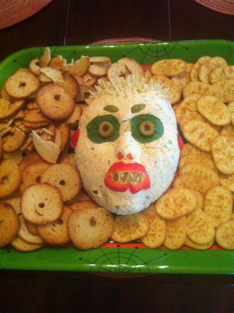A Green Tray Topped With Lots Of Crackers And A Face