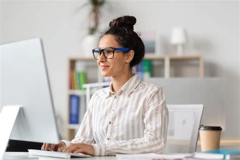 Young Female Entrepreneur Using Computer And Typing Working Online At