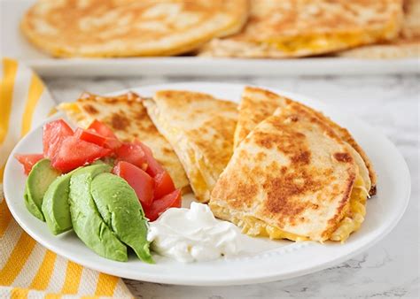 Quesadillas become a meaty main dish with rotisserie chicken, black beans and rice. Easy Cheesy Chicken Quesadilla Recipe | Somewhat Simple