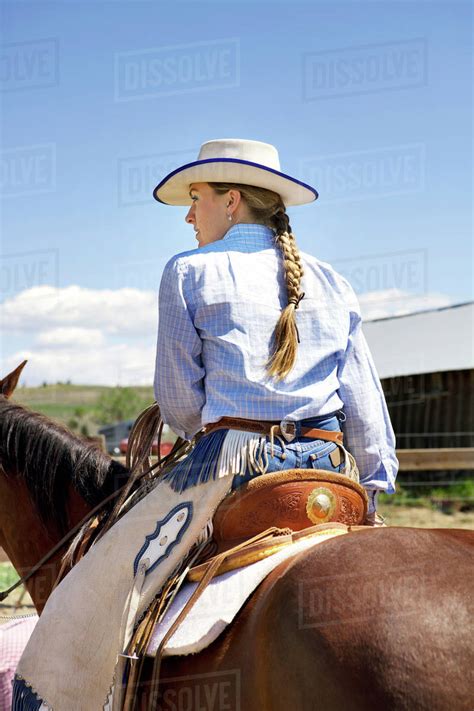 Cowgirl On Her Horse Wearing Chaps And Cowboy Hat Stock