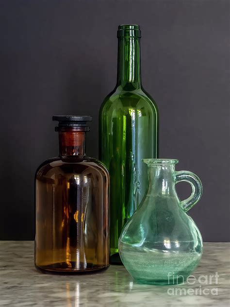 Green And Brown Glass Bottles With Jar On Marble Table With Black Background Window Natural