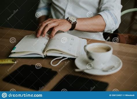 Person Taking Notes In A Notebook While Working From Home Stock Image