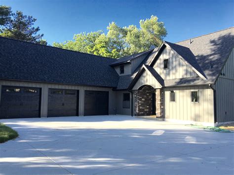 Black home exterior elements, including garage doors, became popular with modern, contemporary home design. Dark grey vertical steel siding with black garage doors ...