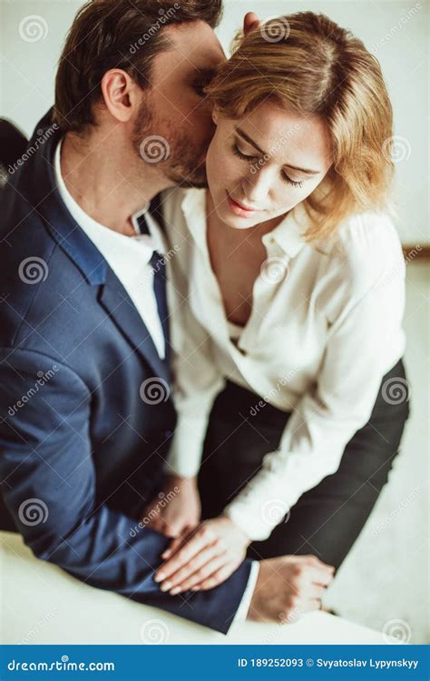 Love Affair At Work Business Man Kisses Neck Of A Woman Sitting On His Lap Two People Flirting