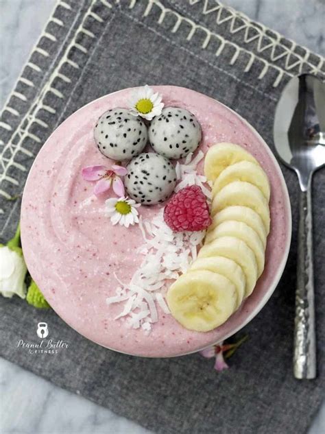 A Pink Smoothie Bowl Topped With Bananas Raspberries And Kiwis