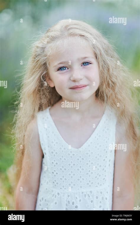 close up portrait of pretty blue eyed fair skinned girl with happy and peaceful expression and