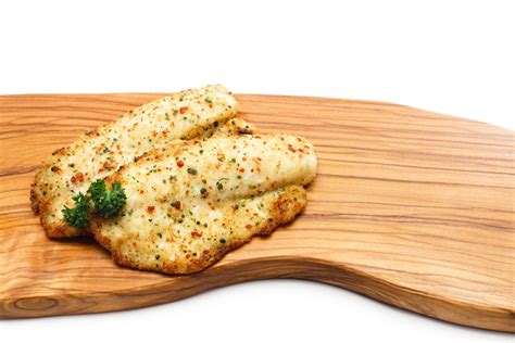 Tilapia fillets are bathed in lemon juice and melted butter, seasoned with garlic and parsley, and baked to flaky perfection. Baked Tilapia Fish Recipe with Crispy Topping