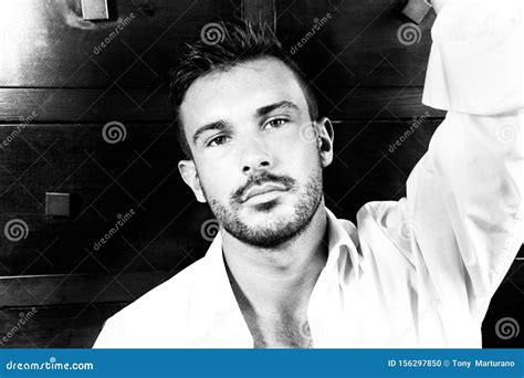 Portrait Of Good Looking Man With Beard And Open Shirt Looking At